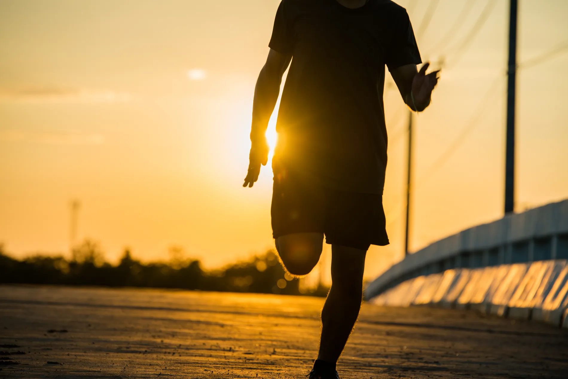 Läufer im Gegenlicht bei Sonnenaufgang als Sinnbild für W12 Running